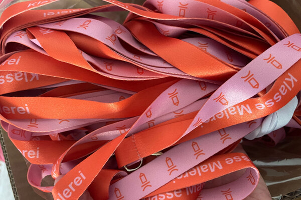 Schlüsselanhänger in orange/pink mit der Aufschrift 'Malereiklasse'