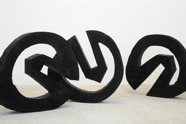 Werner Pokorny, „wheels“, 2009, Khajaholz, gesägt und schwarz gebrannt, ca. 94 cm hoch 