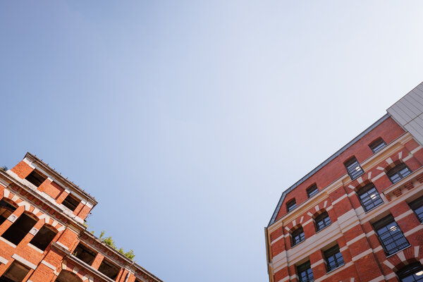 Farbfotografie zweier Gebäudeteile aus extremer Perspektive von unten